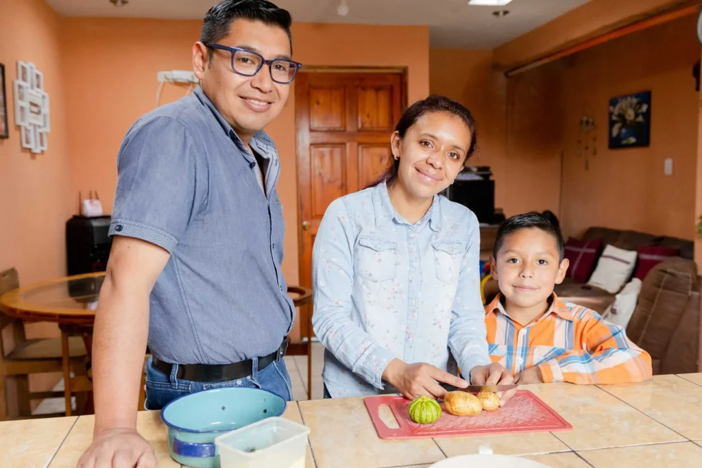 Family together in their kitchen, representing working parents who benefit from child care scholarship cost-sharing through Workforce Solutions Capital Area