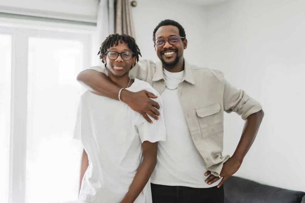 Father and son smiling together at home, representing families supported by parent training resources from Workforce Solutions Capital Area