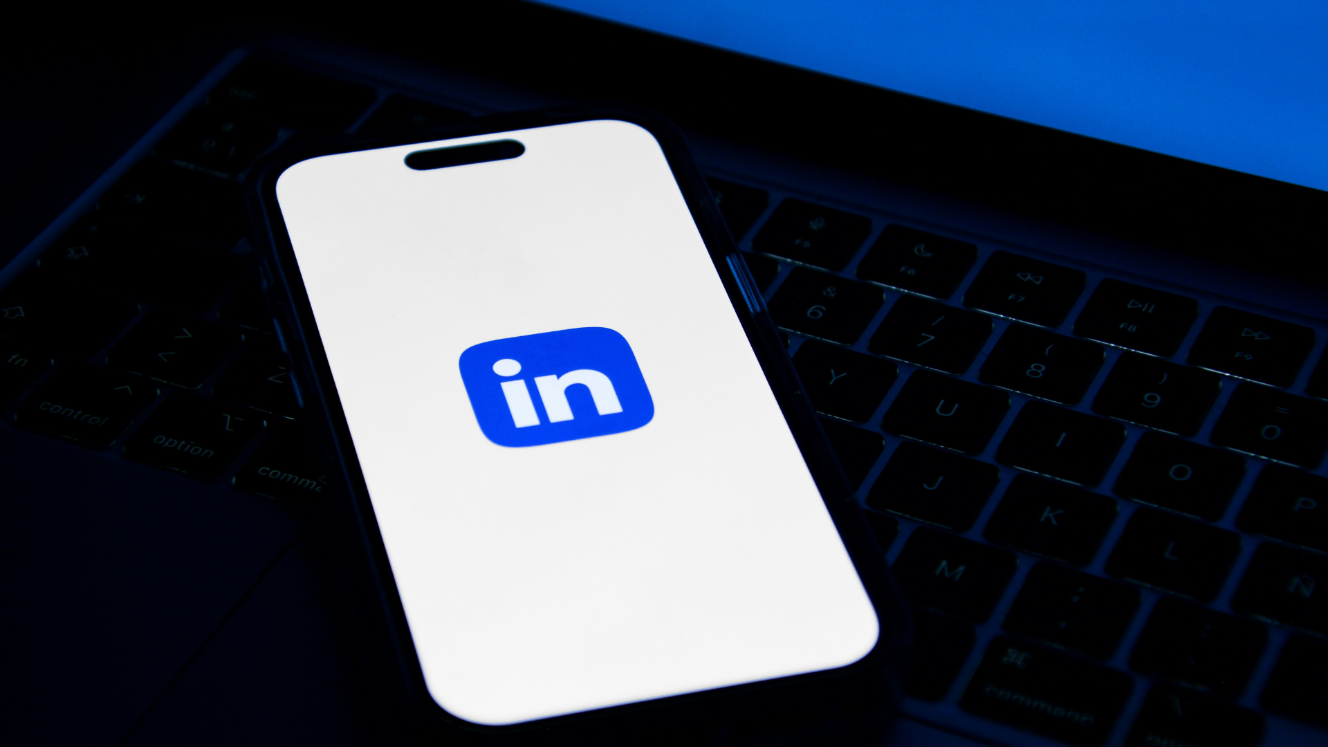 Phone sitting on top of a laptop computer